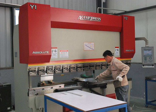 在沖裁機(jī)旁進(jìn)行鈑金加工的工人